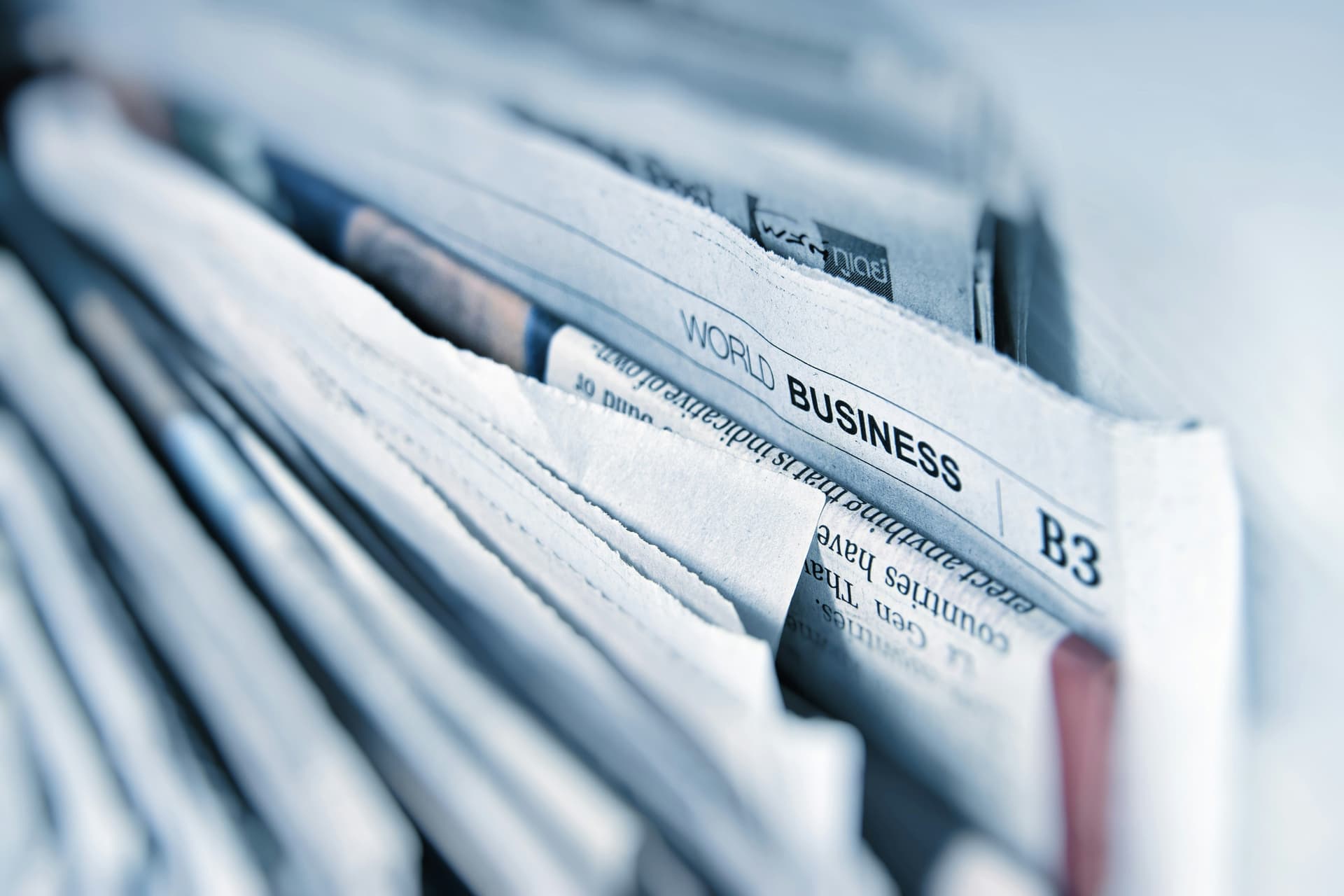 Stacked newspapers on a table in a newsroom