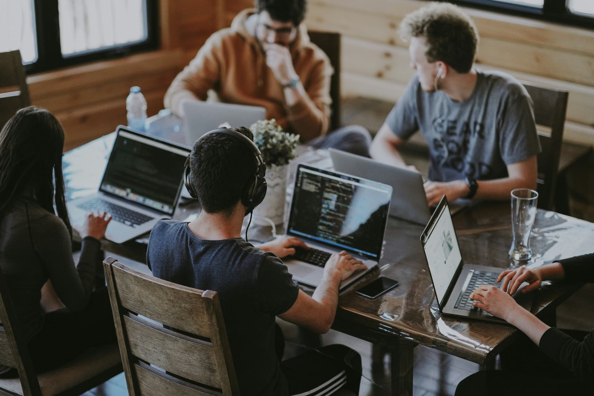 A technology team collaborating around a laptop in a modern office